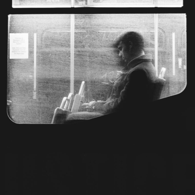 man using phone on the bus